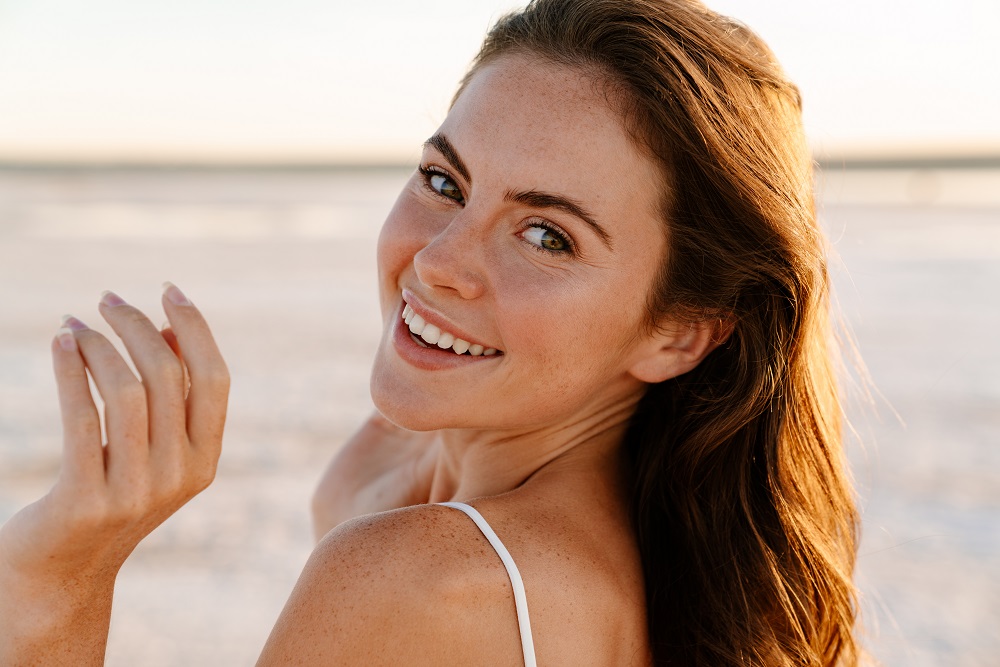 Photoofacheerfulyoungprettygirlwalkingoutdoorsat | Cornerstone Plastic Surgery 