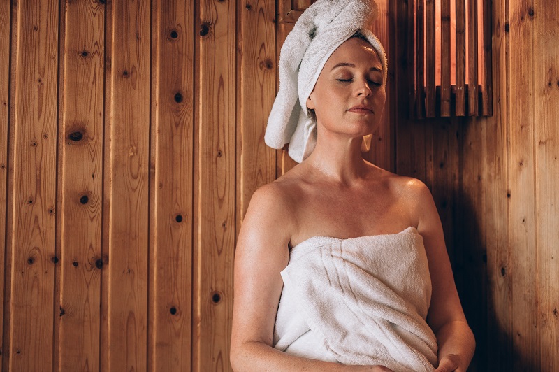 Womanwithtowelwrappedaroundherbodyandheadsitting | Cornerstone Plastic Surgery 