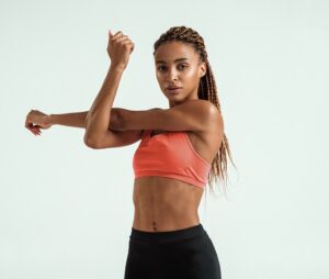 Sportygirlbeautifulyoungafricanwomaninsportswearstretchingher | Cornerstone Plastic Surgery 